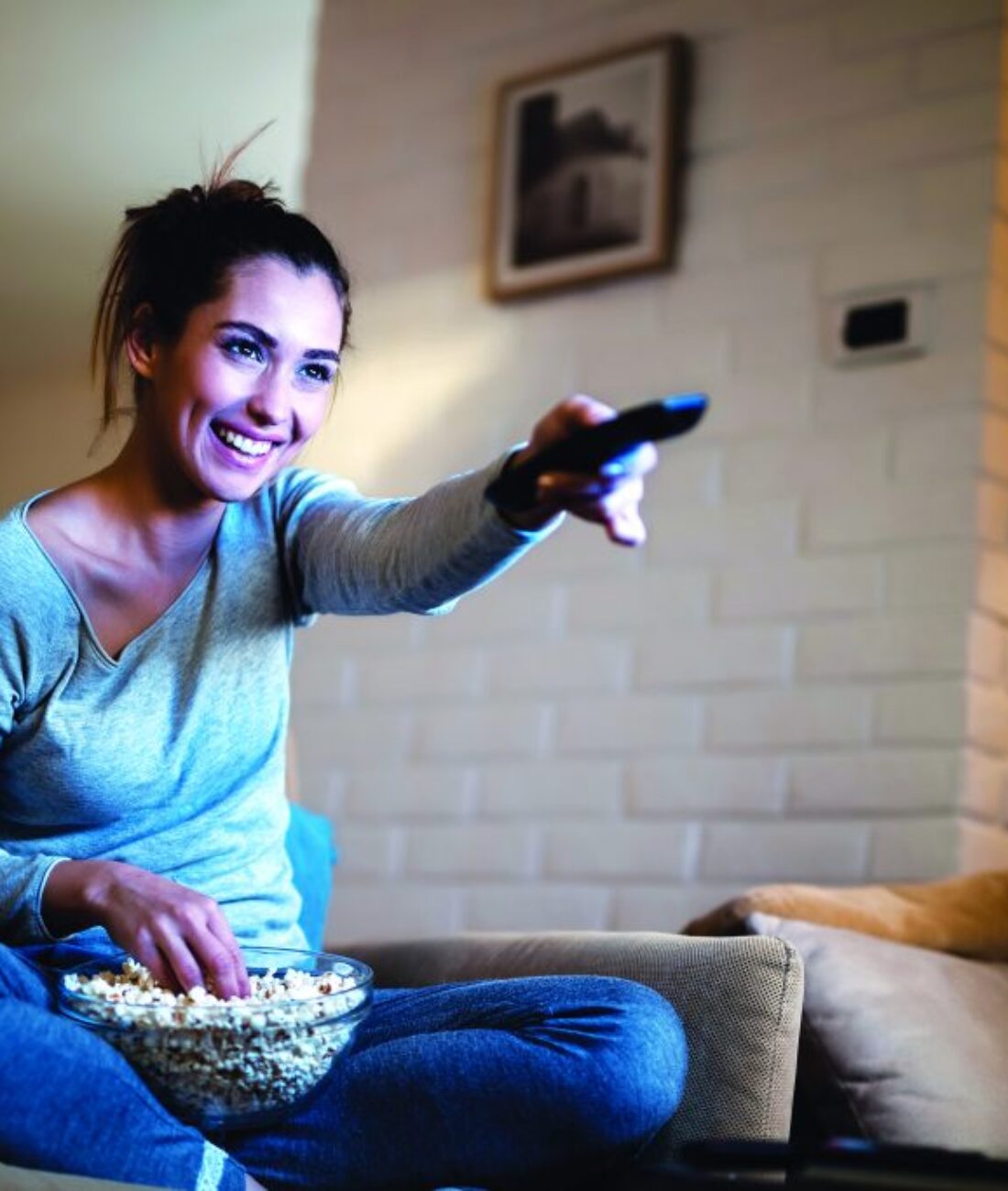 Young,Woman,Having,Fun,While,Changing,Channels,On,Tv,And