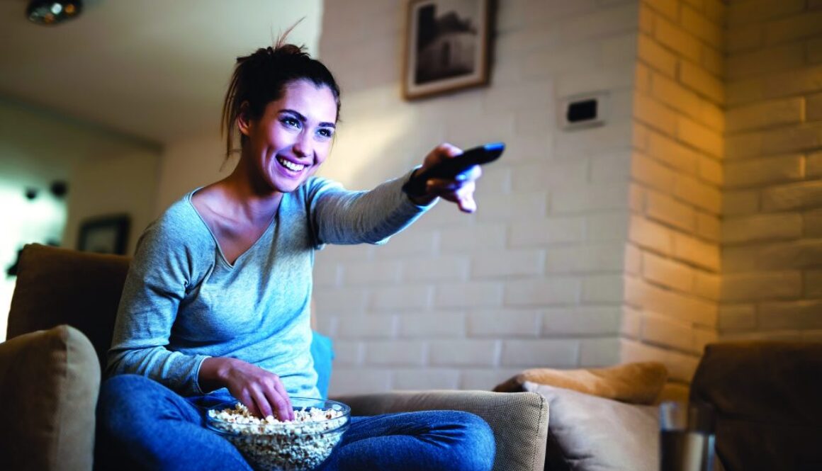 Young,Woman,Having,Fun,While,Changing,Channels,On,Tv,And