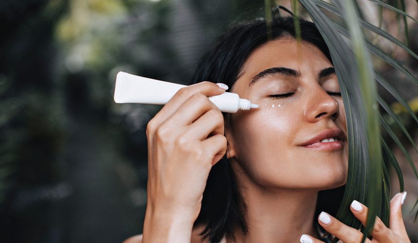 relaxed-woman-applying-sunscreen-joyful-woman-with-face-cream-standing-nature-background